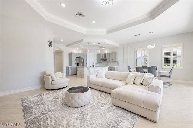 living room with crown molding and a tray ceiling