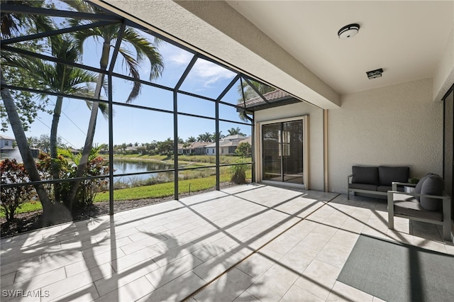 view of patio / terrace featuring an outdoor living space, a lanai, and a water view