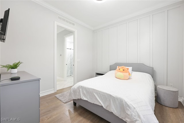 bedroom with crown molding and light wood-type flooring