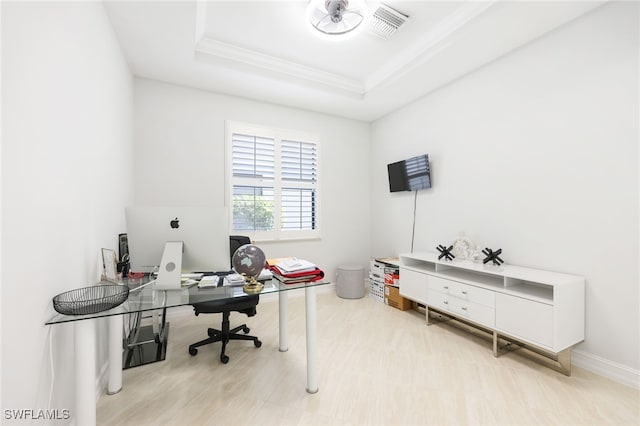 home office with ornamental molding and a raised ceiling