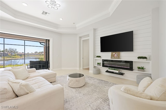 living room with ornamental molding, a raised ceiling, and a water view