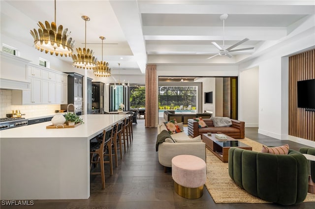 living room with dark hardwood / wood-style floors, ceiling fan, coffered ceiling, and beam ceiling