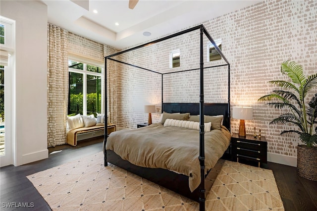 bedroom with hardwood / wood-style flooring, ceiling fan, and brick wall