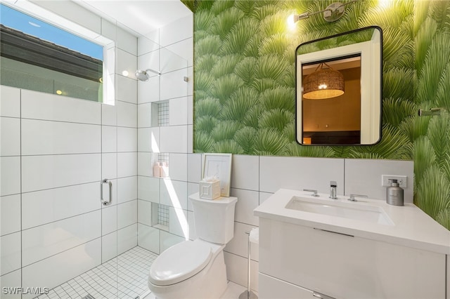 bathroom with toilet, tile walls, vanity, and walk in shower