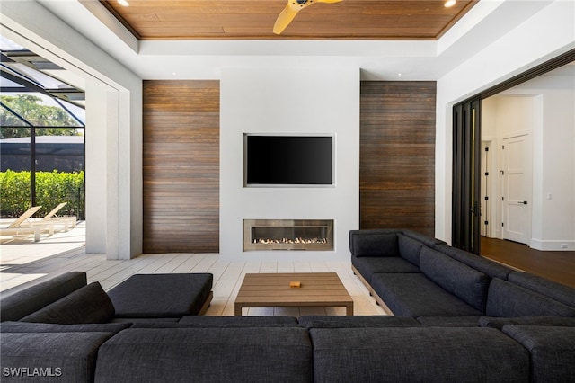 living room featuring a raised ceiling and wooden ceiling