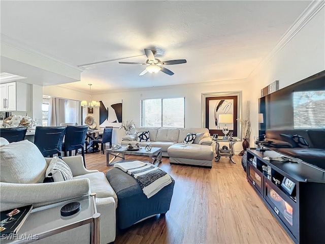 living room featuring ceiling fan with notable chandelier, ornamental molding, and light hardwood / wood-style floors