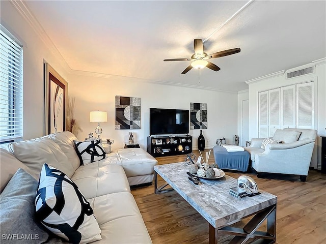 living room with crown molding, hardwood / wood-style floors, and ceiling fan