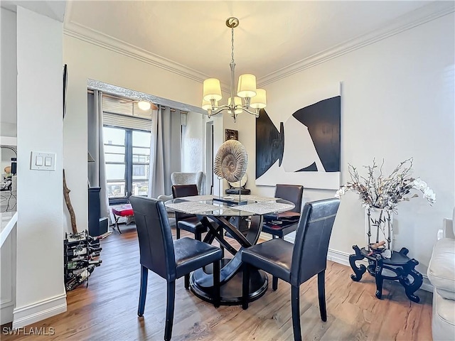 dining room featuring crown molding, hardwood / wood-style floors, and a notable chandelier