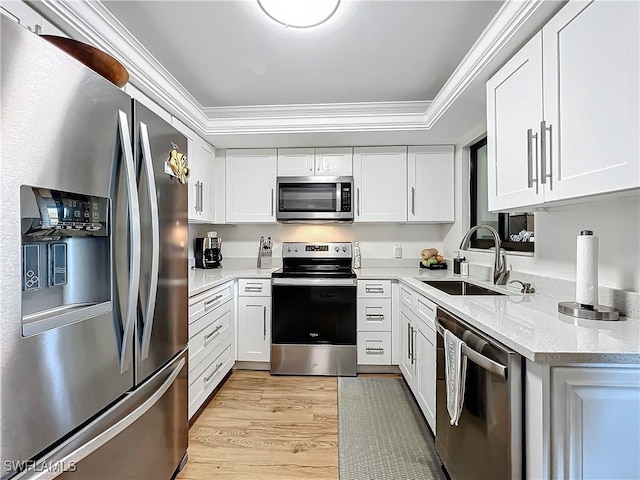 kitchen with sink, white cabinetry, crown molding, stainless steel appliances, and light hardwood / wood-style floors