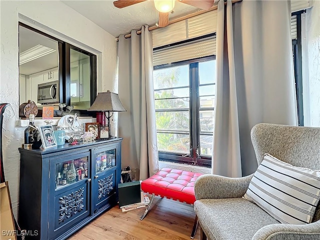 sitting room featuring ceiling fan and light wood-type flooring