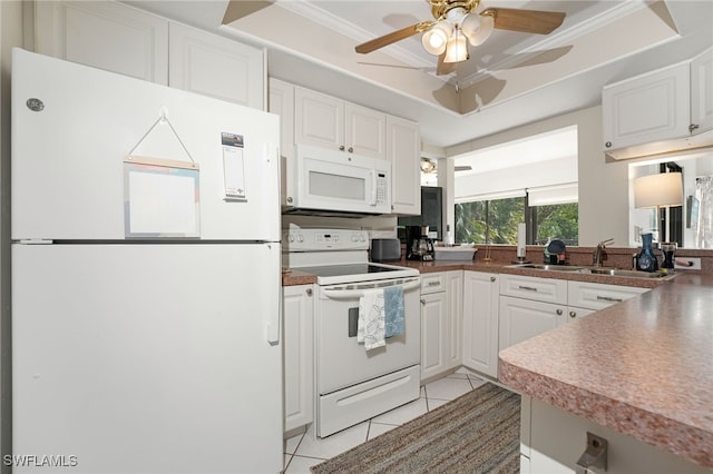 kitchen with light tile patterned flooring, white appliances, a raised ceiling, and white cabinets