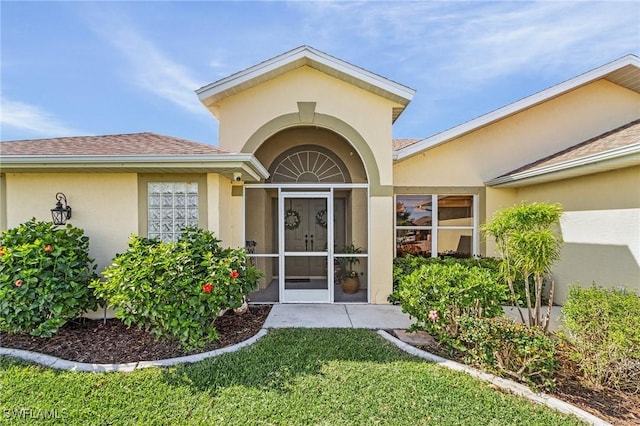 property entrance with a lawn