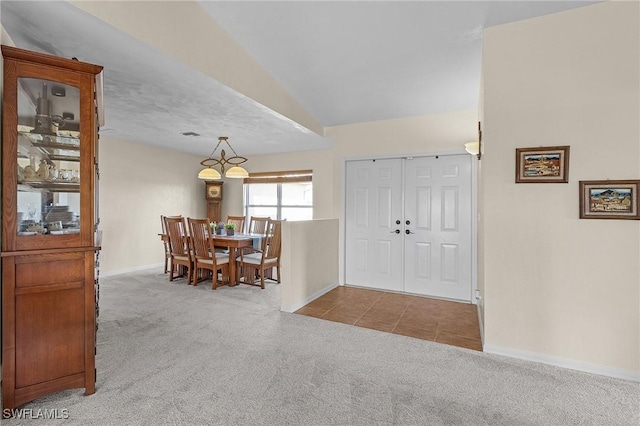 carpeted foyer featuring lofted ceiling