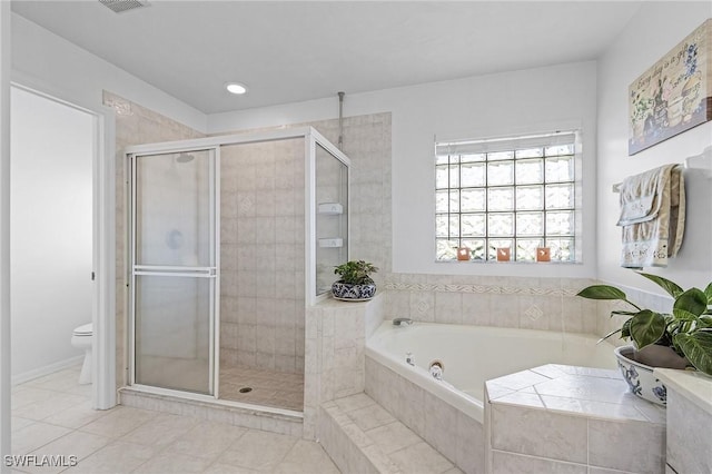 bathroom featuring tile patterned floors, toilet, and separate shower and tub