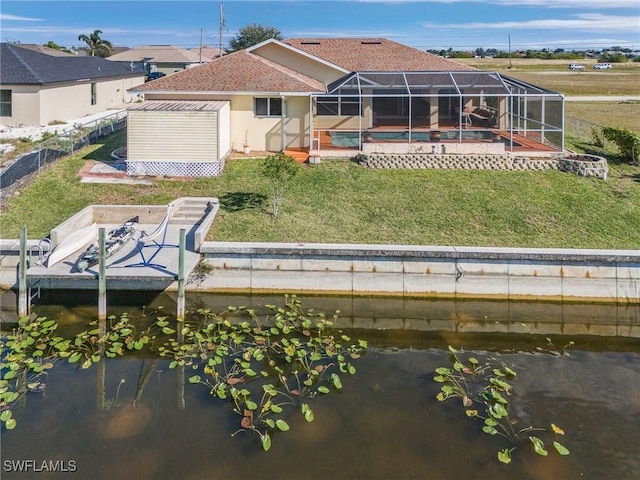 rear view of property featuring a water view, a lanai, a storage shed, and a lawn