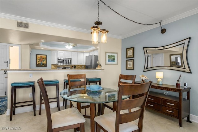 dining space featuring light tile patterned floors, ornamental molding, and a raised ceiling