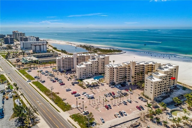 birds eye view of property with a water view and a beach view