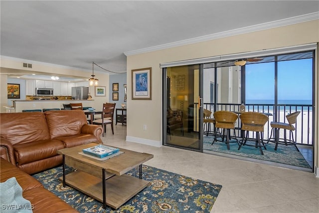 tiled living room with crown molding and a water view