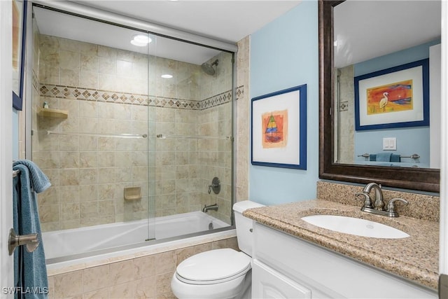 full bathroom with vanity, enclosed tub / shower combo, and toilet