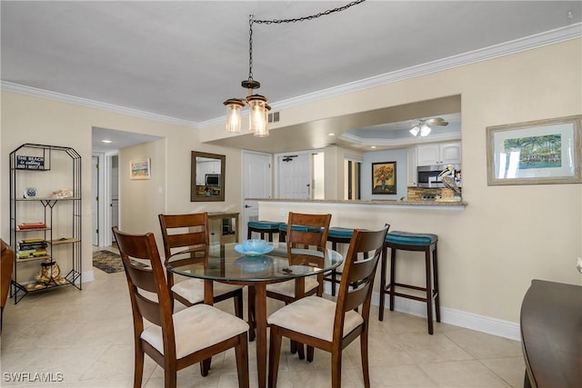 dining area featuring crown molding, light tile patterned floors, and a tray ceiling