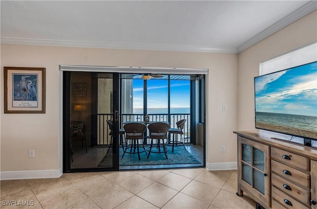 dining room featuring crown molding, light tile patterned flooring, and a wealth of natural light