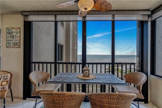 sunroom / solarium featuring a water view and ceiling fan