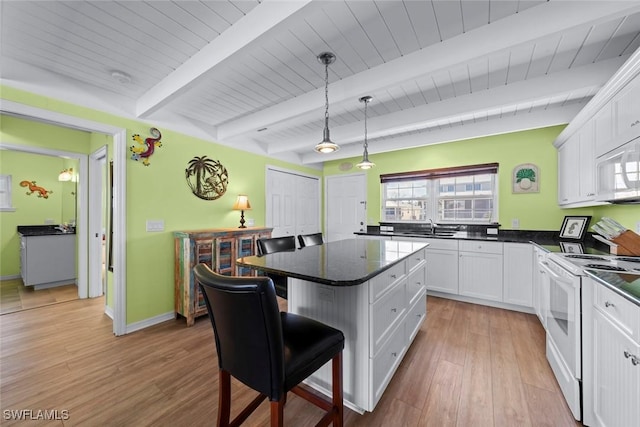 kitchen featuring a kitchen bar, white cabinetry, a kitchen island, pendant lighting, and white appliances