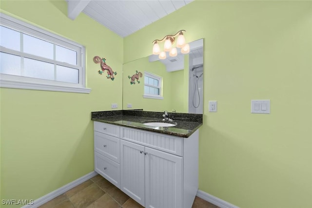 bathroom featuring plenty of natural light, beam ceiling, and vanity