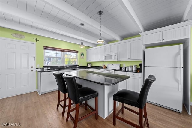 kitchen featuring white cabinetry, hanging light fixtures, a kitchen island, beamed ceiling, and white appliances