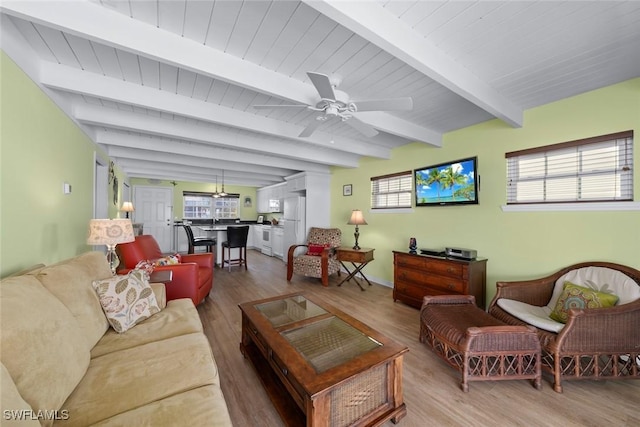 living room featuring hardwood / wood-style floors, beamed ceiling, and ceiling fan