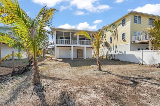 back of property with a garage and a sunroom