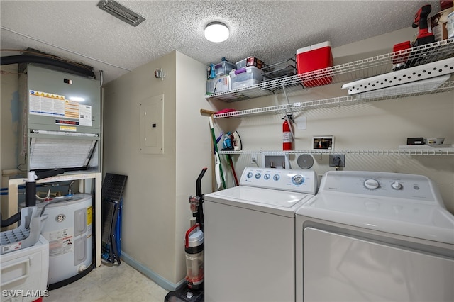 laundry area with electric panel, washing machine and dryer, water heater, and a textured ceiling