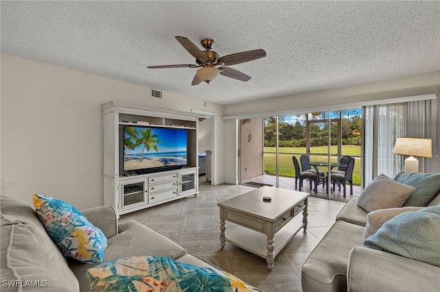 living room with ceiling fan and a textured ceiling