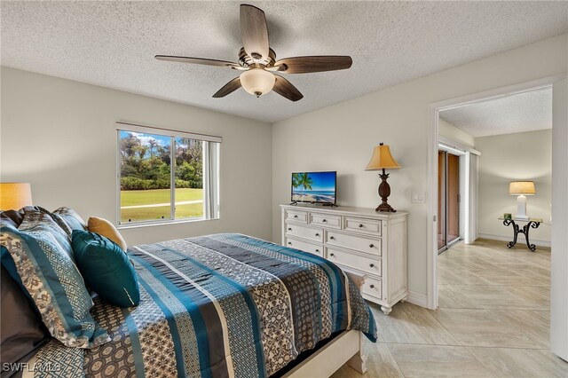 7025 Dennis Cir Unit G104, Naples, FL 34104 - bedroom featuring a textured ceiling, ceiling fan, and baseboards