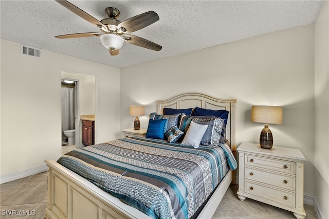 7025 Dennis Cir Unit G104, Naples, FL 34104 - bedroom with a textured ceiling, baseboards, connected bathroom, and ceiling fan
