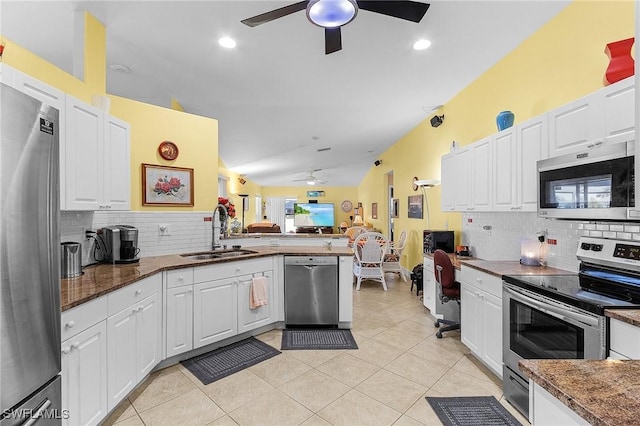 kitchen with sink, white cabinetry, light tile patterned floors, appliances with stainless steel finishes, and kitchen peninsula