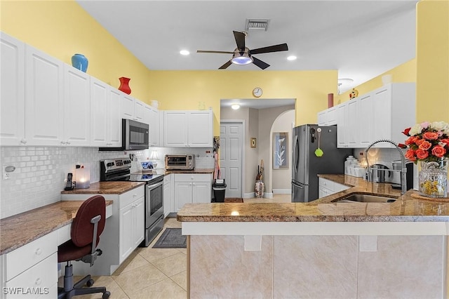 kitchen with appliances with stainless steel finishes, white cabinetry, sink, decorative backsplash, and kitchen peninsula