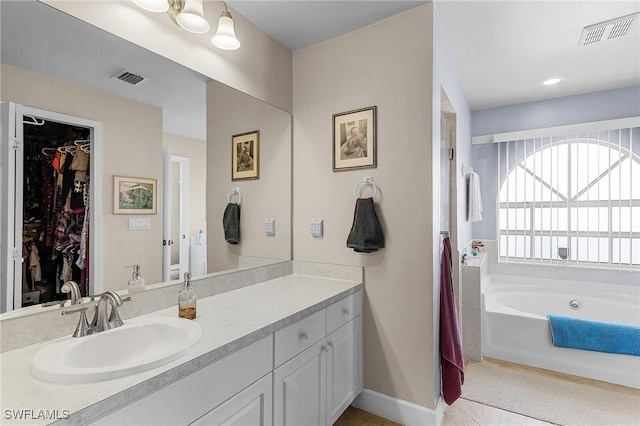 bathroom with vanity, a bathing tub, and toilet