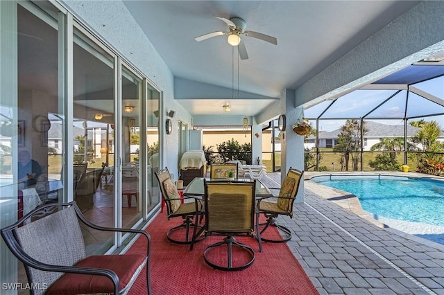 view of swimming pool with ceiling fan, a lanai, and a patio