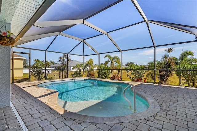 view of swimming pool featuring a lanai and a patio area