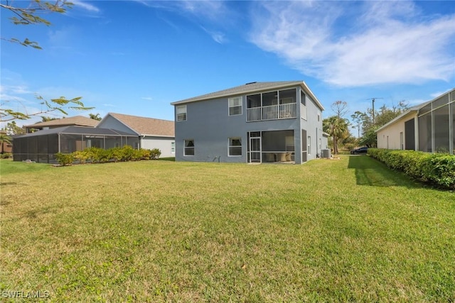 rear view of house featuring stucco siding and a lawn