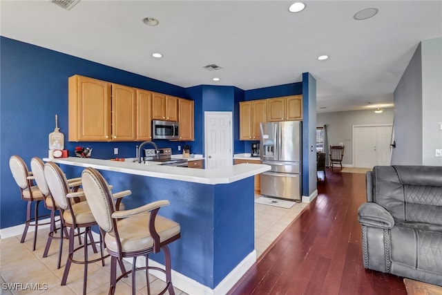 13380 Hampton Park Ct, Fort Myers, FL 33913 - kitchen featuring appliances with stainless steel finishes, light countertops, baseboards, a peninsula, and a breakfast bar area
