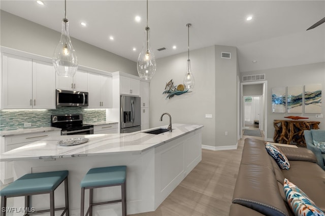 kitchen featuring white cabinetry, sink, backsplash, and appliances with stainless steel finishes