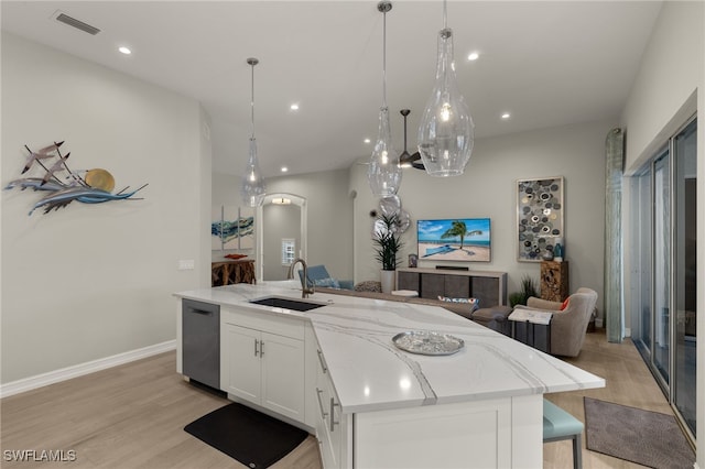 kitchen featuring sink, decorative light fixtures, dishwashing machine, a kitchen island with sink, and white cabinets