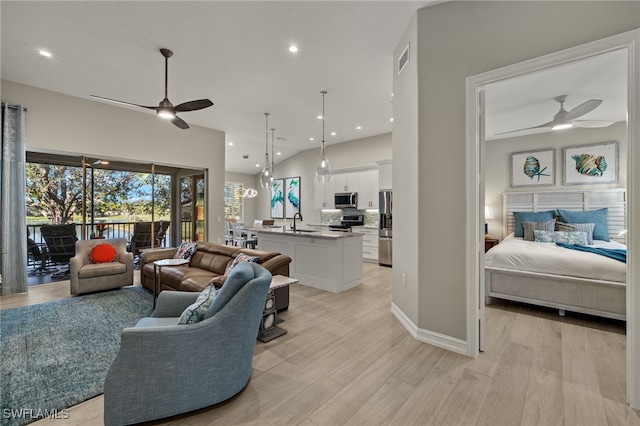 living room featuring high vaulted ceiling, sink, ceiling fan, and light hardwood / wood-style flooring