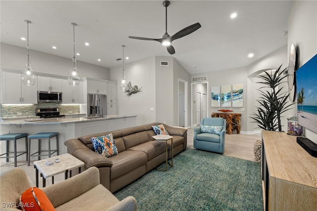 living room featuring ceiling fan, sink, and hardwood / wood-style floors