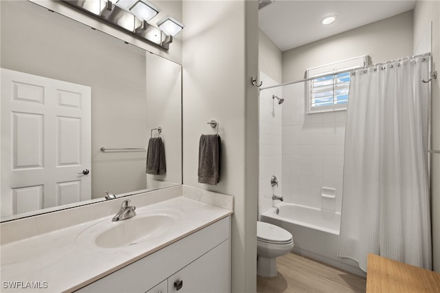 full bathroom featuring vanity, hardwood / wood-style floors, shower / tub combo with curtain, and toilet