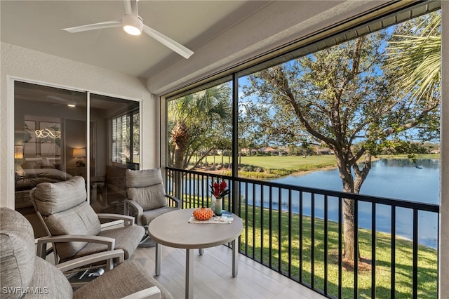 sunroom / solarium featuring a water view, ceiling fan, and a wealth of natural light