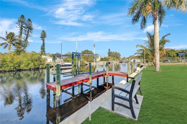 view of dock with a water view and a lawn