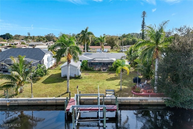 view of dock featuring a lawn and a water view